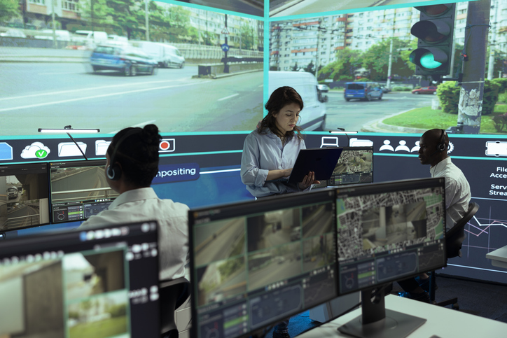 Man and woman behind a wall of data screens