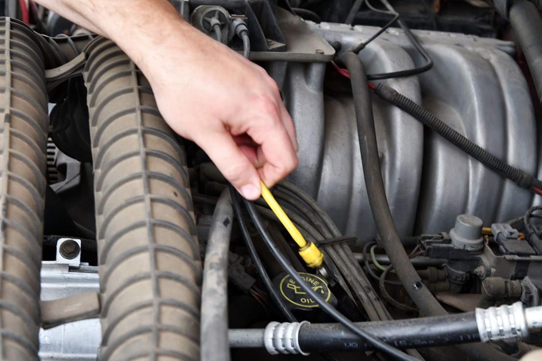 This is an image of a hand doing repairs to an engine on a car
