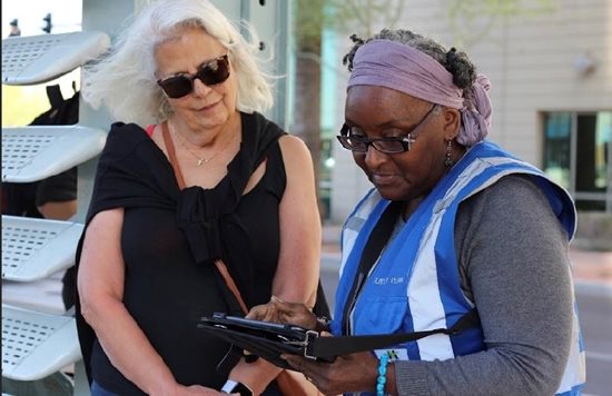 Two women reviewing a survey in a suburban area.