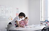 Two women standing desk looking at documennts