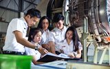 Group of students in hangar around airplaneengine 