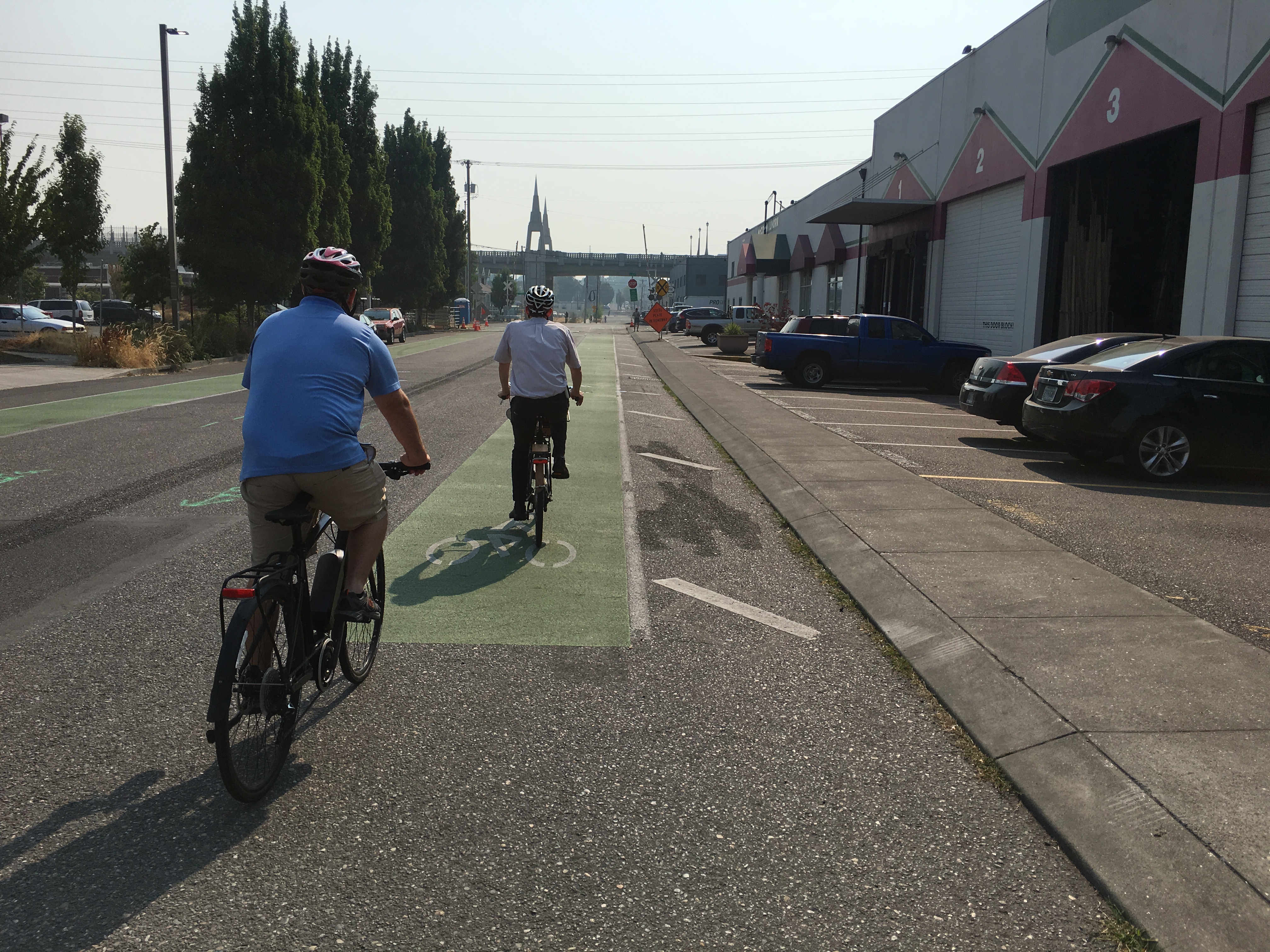 Individuals riding their bikes on a marked bike lane