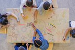 Several kids drawing pictures with crayons 