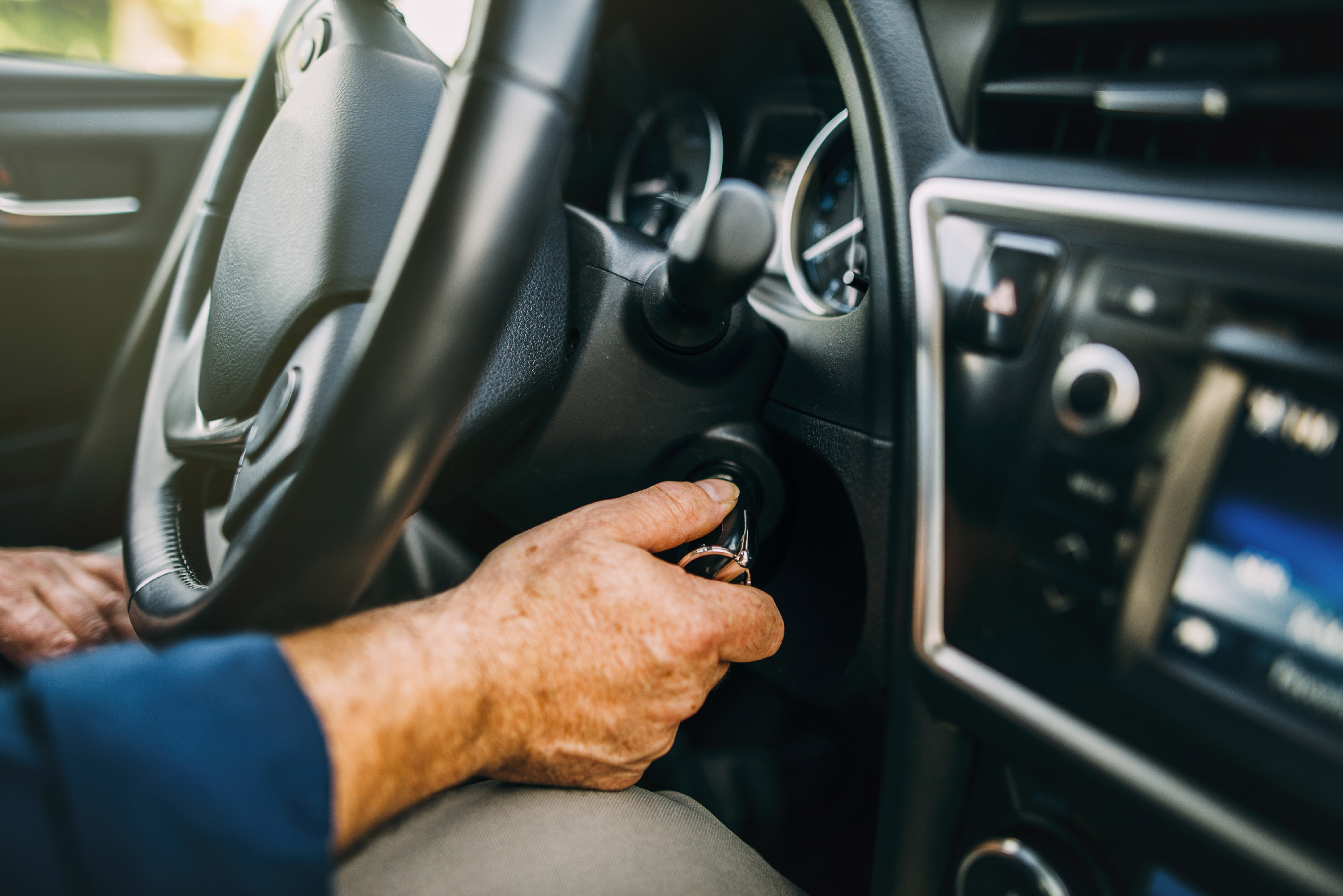 This is an image of a man starting a car