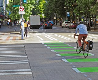 Cyclist with helmets riding along roadway.