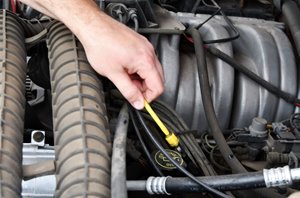 This is an image of a hand doing repairs to an engine on a car