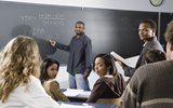 Man standing in front of a class large black board