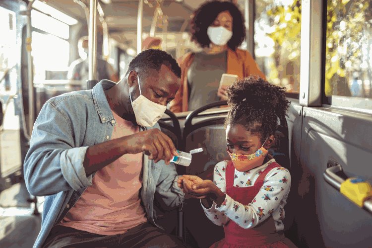 Family wearing masks on a transit vehicle.