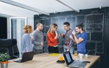 Group of workers standing around a table 