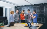 Group of workers standing around a table 